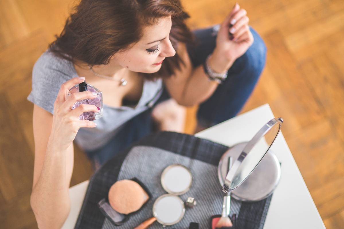 An overhead view of a woman applying perfume