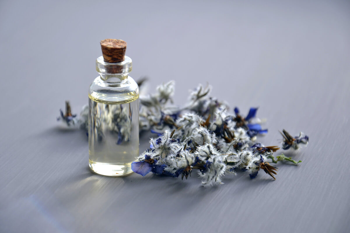 Selective focus photo of bottle with cork lid and dried herbs